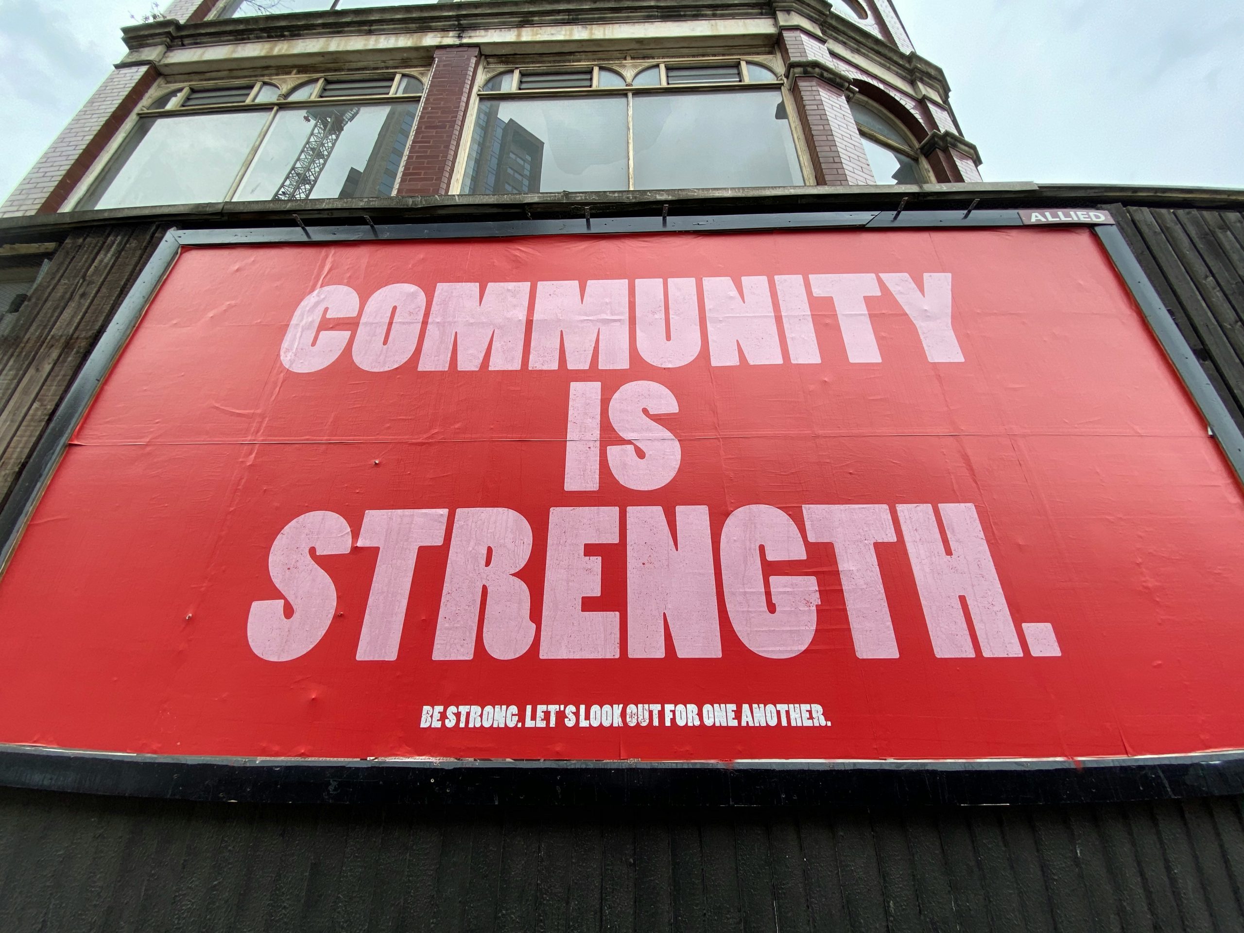 Red sign that says "Community is Strength" in bold letters.